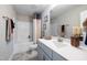 Clean and bright bathroom featuring white countertops, gray cabinetry, and tiled shower at 1788 Farm Pond Trl, Durham, NC 27703