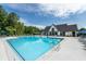 Large community pool with a clubhouse, lounge chairs, and surrounding trees at 1788 Farm Pond Trl, Durham, NC 27703