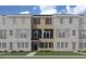 Attractive three-story townhome with brick and siding exterior, front balcony, and green lawn at 217 Broomgrove Way, Wake Forest, NC 27587