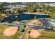 An aerial view of a park shows a pond, tennis court, baseball fields, and playground at 261 Hank Way, Angier, NC 27501