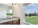 Bathroom vanity with granite countertop, double sinks, and a large window overlooking greenery at 261 Hank Way, Angier, NC 27501