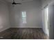 Spacious bedroom with wood-look flooring, ceiling fan, and sliding barn door to ensuite at 310 E Woodall St, Smithfield, NC 27577