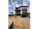 A modern three-story home viewed from an angle showing the driveway and some construction materials at 409 Waldo St, Cary, NC 27511