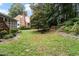 Backyard with screened porch, lush landscaping, and stone pathway at 421 Weathergreen Dr, Raleigh, NC 27615