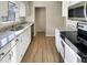 Updated kitchen featuring white cabinetry, granite countertops, and stainless steel appliances at 5038 Flint Ridge Pl, Raleigh, NC 27609