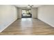 Empty living room with wood-look floors and sliding glass door leading to a balcony at 5038 Flint Ridge Pl, Raleigh, NC 27609