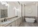 Modern bathroom featuring dual vanities, a soaking tub, and a glass-enclosed shower at 5328 Bent Leaf Dr, Raleigh, NC 27606