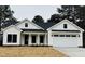 Charming white two-story farmhouse with a two-car garage and a covered front porch at 601 Vannoy Pl, Fuquay Varina, NC 27526