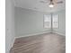 Bright, airy bedroom with wood-like flooring, neutral walls, and multiple windows at 670 Mcadams Rd, Hillsborough, NC 27278