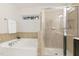 Bathroom with soaking tub, glass shower, and tiled walls at 717 Grace Hodge Dr, Cary, NC 27519