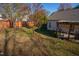 Sloped backyard with wooden fence, trees, and covered patio at 8325 Neuse Grove Ln, Raleigh, NC 27616