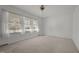 Empty living room with carpet, white walls, large windows, and a ceiling fan at 920 Essex Dr, Graham, NC 27253