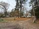 Mobile home with dirt driveway, trees, and neighboring homes in the background at 923 Sunny Ln, Raleigh, NC 27603
