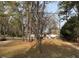Single-wide mobile home with a dirt driveway nestled among trees at 923 Sunny Ln, Raleigh, NC 27603