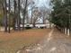 View of a mobile home from the driveway, surrounded by trees at 923 Sunny Ln, Raleigh, NC 27603