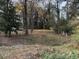 An expansive yard area with a backdrop of trees and a split-rail fence at 923 Sunny Ln, Raleigh, NC 27603