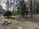 Grassy yard with a small ditch, shrubs, trees, and fallen leaves at 923 Sunny Ln, Raleigh, NC 27603