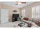 Living room with a comfortable sectional sofa, entertainment center, and plantation shutters at 1105 Ventnor Pl, Cary, NC 27519