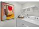 Laundry room with white Whirlpool washer and dryer and ample shelving at 119 Ethel Ln, Angier, NC 27501