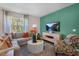 Cozy living room with a sectional sofa, accent chair, and large window at 119 Ethel Ln, Angier, NC 27501