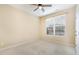 Empty bedroom with large window, ceiling fan, and neutral-colored carpet at 2204 Regent Ct, Creedmoor, NC 27522