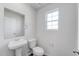 Clean, modern bathroom with white fixtures, a pedestal sink, and a window at 228 Maggie Ln, Roxboro, NC 27573