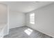 Bright, empty bedroom with a single window and wood-style flooring at 228 Maggie Ln, Roxboro, NC 27573
