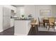 Modern kitchen with white cabinets, dark countertops, stainless steel appliances, and an island with seating at 228 Maggie Ln, Roxboro, NC 27573