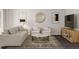 Living room with neutral-toned furniture, a large decorative mirror, a wooden entertainment center, and a patterned rug at 228 Maggie Ln, Roxboro, NC 27573