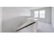 Carpeted loft area with a staircase and windows at 228 Maggie Ln, Roxboro, NC 27573