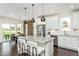 Modern kitchen featuring white cabinets, stainless steel appliances, and a large island with seating at 2317 Forsythia Trl, Fuquay Varina, NC 27526