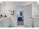 View of main bathroom with dual sink vanity and open door to the main bedroom at 26 Shay St, Angier, NC 27501