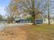 Backyard view of a gray and brick house with a gravel driveway and a storage shed at 320 W Orange St, Hillsborough, NC 27278