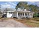 White two-story home with covered porch, driveway, and trees at 330 Poplar St, Wendell, NC 27591