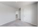 Empty bedroom with gray carpet, white walls, a closed door, and open doorway at 36 Andrea Ct, Roxboro, NC 27573