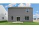 View of the back of a two-story house with gray siding and a patio at 432 Ashley Run, Sanford, NC 27330