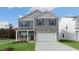 New two-story home with stone accents, front porch, and attached two-car garage at 432 Ashley Run, Sanford, NC 27330