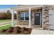 Covered front porch with stone accents and dark gray front door at 432 Ashley Run, Sanford, NC 27330