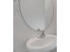 Powder room with pedestal sink and circular mirror at 432 Ashley Run, Sanford, NC 27330
