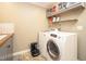 Laundry room with white washer and dryer, gray cabinets, and tiled backsplash at 7800 Secluded Acres Rd, Apex, NC 27523