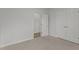 Empty bedroom with carpet, double doors, and open door at 112 Edgewood Dr, Roxboro, NC 27573