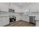 Modern kitchen featuring stainless steel appliances, white cabinets, and granite countertops at 112 Edgewood Dr, Roxboro, NC 27573