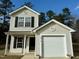 Two-story house with beige vinyl siding, black shutters, and a garage at 2816 Smoke Pl, Raleigh, NC 27610