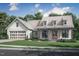 Charming two-story farmhouse with a metal roof, multiple dormers, and an attached two-car garage at 2850 Sheep Pasture Rd, Spring Hope, NC 27882
