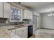 Modern kitchen with white cabinets, stainless steel appliances, and access to the backyard at 1506 Poplar Ridge Rd, Fuquay Varina, NC 27526