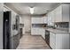 Updated kitchen boasts white cabinets, modern appliances, and stylish backsplash at 1506 Poplar Ridge Rd, Fuquay Varina, NC 27526