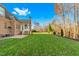Expansive backyard with a lush green lawn and trees, a patio, and an outdoor grill at 4109 Cheek Point Pl, Burlington, NC 27215