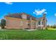 Back exterior of the house featuring a screened porch and a lush green lawn at 4109 Cheek Point Pl, Burlington, NC 27215