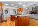 Open kitchen with island, granite countertops, and wood cabinetry at 4109 Cheek Point Pl, Burlington, NC 27215