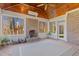 Bright sunroom featuring brick fireplace, wood ceiling, and access to backyard at 4109 Cheek Point Pl, Burlington, NC 27215